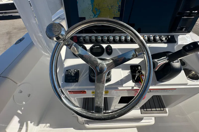 Slide: The Image of 2024 Sea Hunt Ultra 219 boat dashboard with steering wheel and controls. - 70