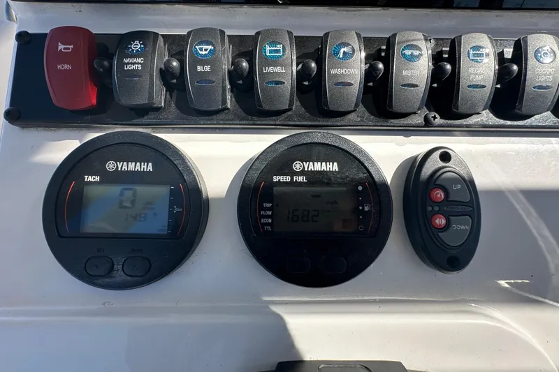 Slide: The Image of 2024 Sea Hunt Ultra 219 dashboard with Yamaha gauges and control switches. - 74