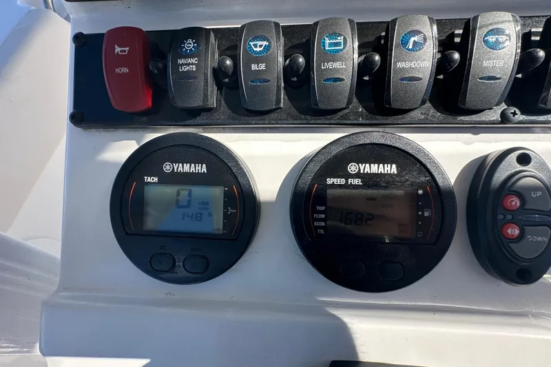 Slide: The Image of 2024 Sea Hunt Ultra 219 dashboard with Yamaha gauges and control switches. - 76