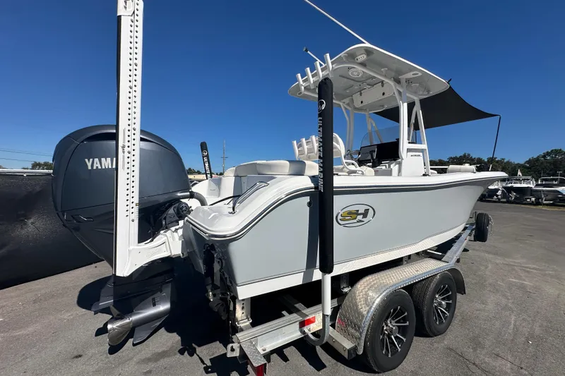 Slide: The Image of 2024 Sea Hunt Ultra 219 boat on trailer with Yamaha engine, parked outdoors. - 8
