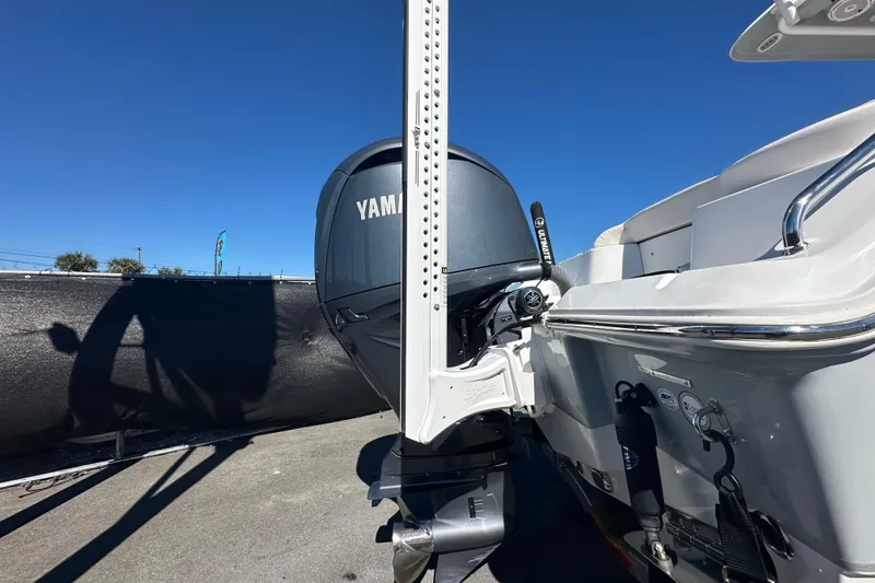 Slide: The Image of 2024 Sea Hunt Ultra 219 boat with Yamaha outboard motor, docked under clear blue sky. - 9