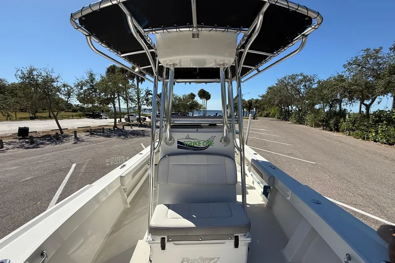 Slide: The Image of 2022 Parker 2100 Special Edition boat with T-top, parked near waterfront. - 16