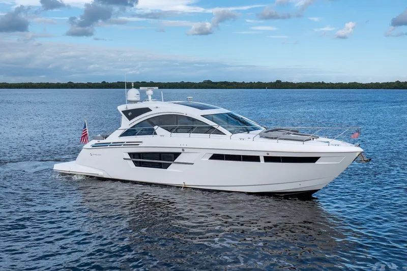 The Image of 2022 Cruisers Yachts 54 Cantius on water with city skyline background. - 0