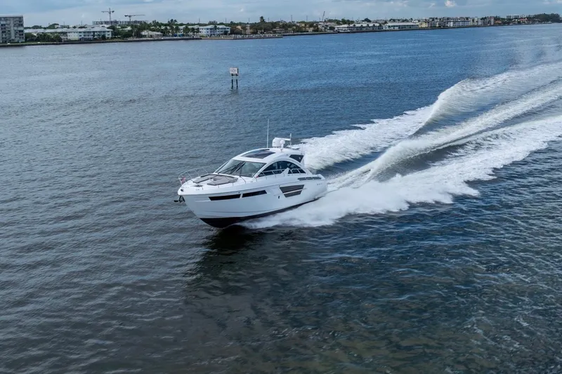 Slide: The Image of 2022 Cruisers Yachts 54 Cantius speeding on open water. - 12