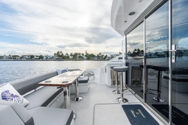 Slide: The Image of 2022 Cruisers Yachts 54 Cantius luxury deck with seating and scenic waterfront view. - 19