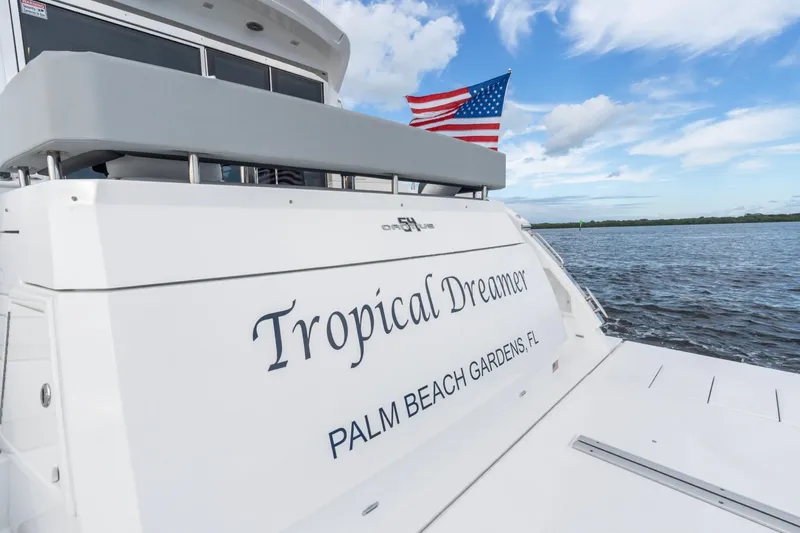 Slide: The Image of 2022 Cruisers Yachts 54 Cantius, "Tropical Dreamer," on water with American flag. - 20