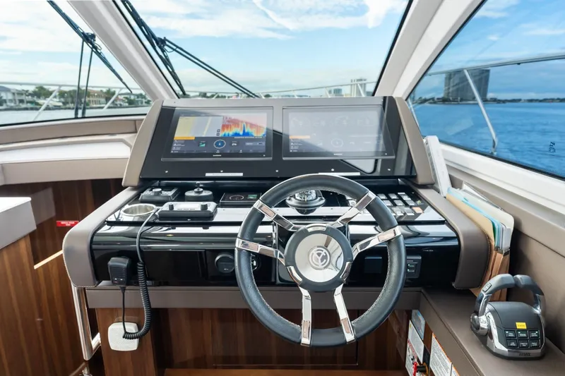 Slide: The Image of 2022 Cruisers Yachts 54 Cantius helm with advanced navigation displays and steering wheel. - 30