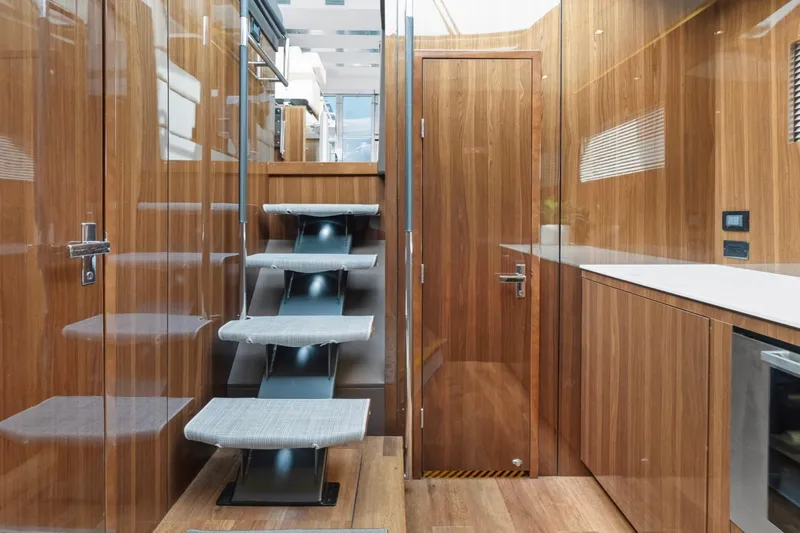 Slide: The Image of Luxurious interior of 2022 Cruisers Yachts 54 Cantius with modern wooden finishes and sleek staircase. - 38