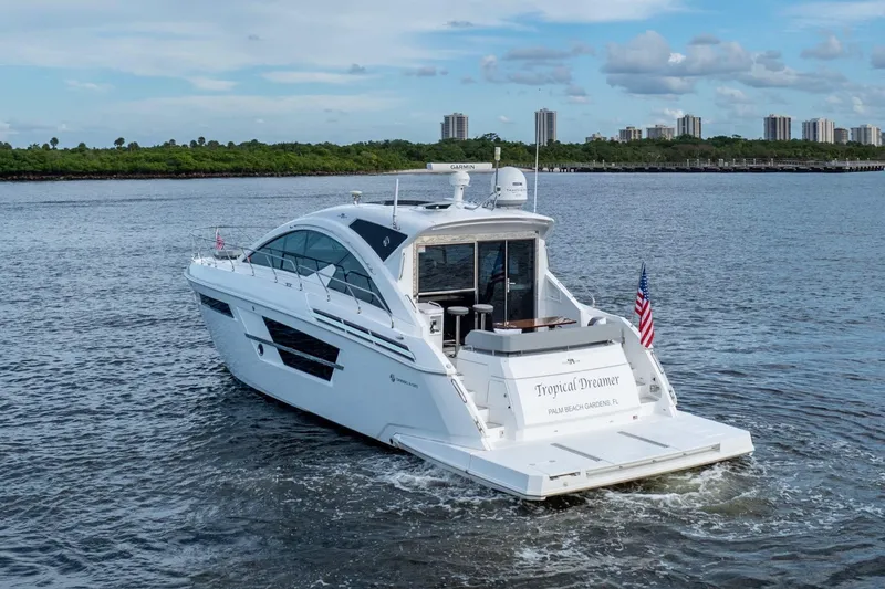 Slide: The Image of 2022 Cruisers Yachts 54 Cantius on water, rear view, with city skyline background. - 5