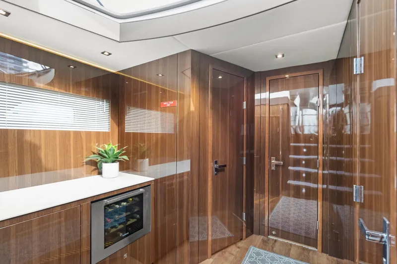 Slide: The Image of Luxurious interior of 2022 Cruisers Yachts 54 Cantius with wood paneling and mini fridge. - 53