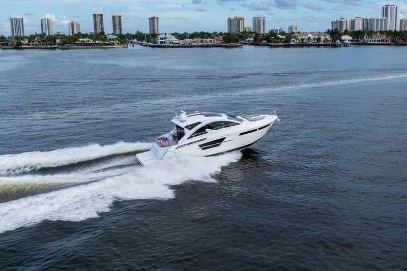 Slide: The Image of 2022 Cruisers Yachts 54 Cantius on serene water under blue sky. - 8