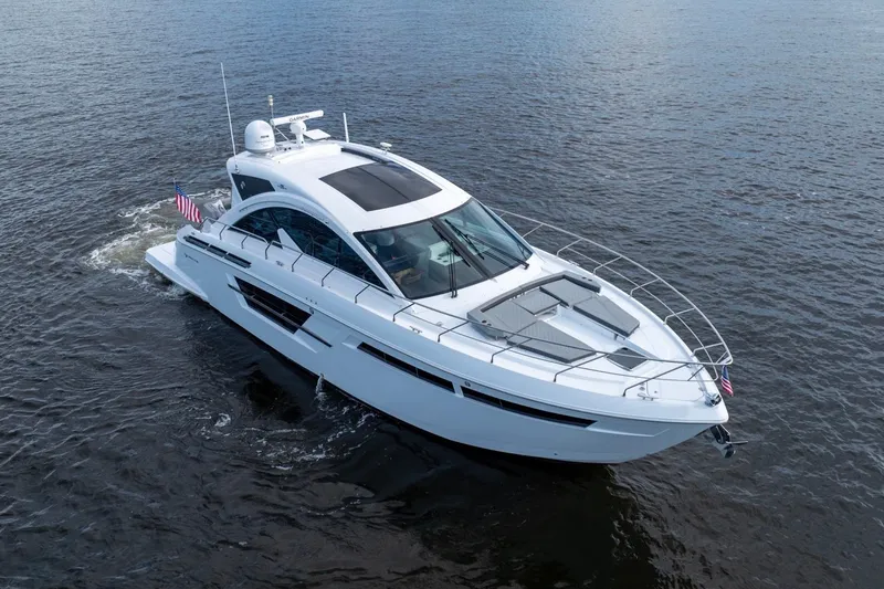 Slide: The Image of 2022 Cruisers Yachts 54 Cantius cruising on a scenic waterway with city skyline. - 9