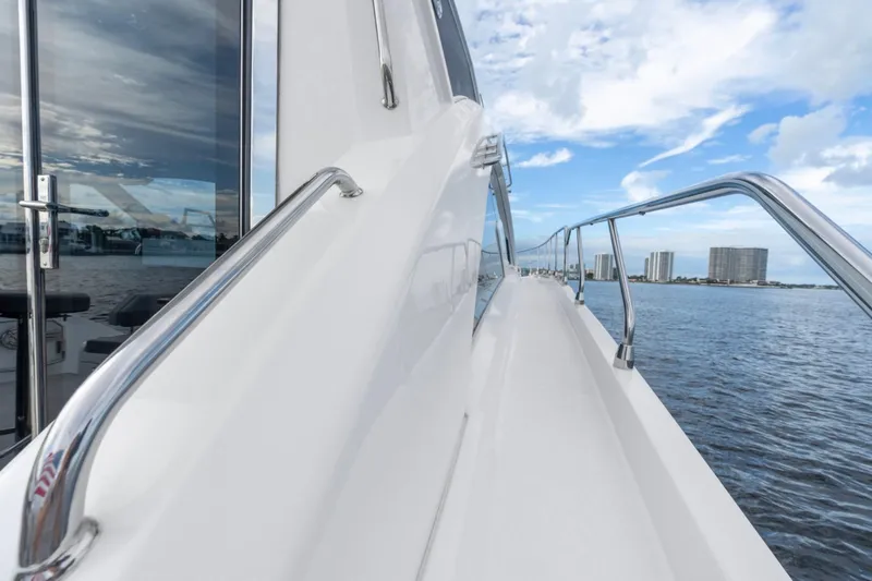 Slide: The Image of 2022 Cruisers Yachts 54 Cantius side deck with ocean view and city skyline. - 18