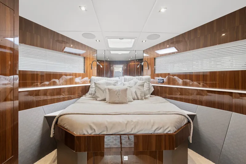Slide: The Image of Luxurious 2022 Cruisers Yachts 54 Cantius bedroom with elegant wood paneling and plush bedding. - 55