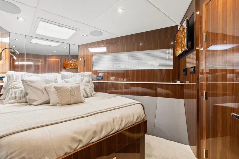 Slide: The Image of Luxurious 2022 Cruisers Yachts 54 Cantius bedroom with elegant wood paneling and plush bedding. - 57
