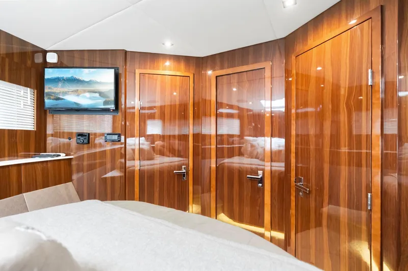 Slide: The Image of Luxurious interior of 2022 Cruisers Yachts 54 Cantius with wood paneling and mounted TV. - 58
