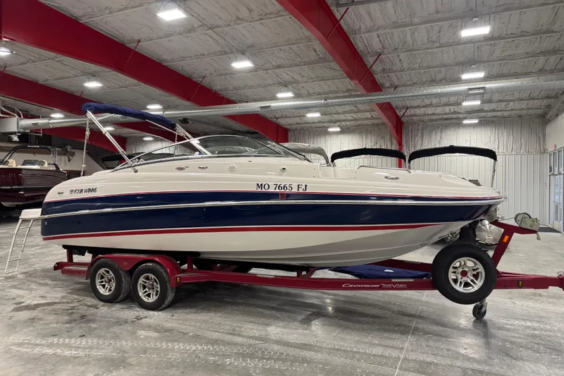 The Image of 2006 Four Winns 244 Funship boat on red trailer in indoor storage facility. - 1