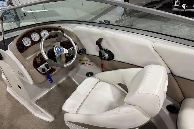 Slide: The Image of 2006 Four Winns 244 Funship boat interior with steering wheel and white seating. - 11