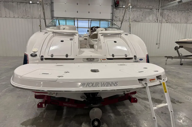 Slide: The Image of 2006 Four Winns 244 Funship boat in a garage, rear view with swim platform. - 5