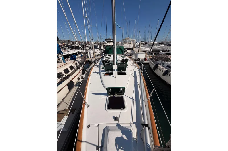 Slide: The Image of 2003 Beneteau Oceanis Clipper 473 sailboat docked in a marina, surrounded by other boats. - 22