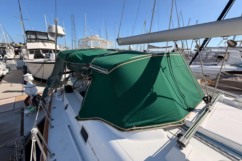 Slide: The Image of 2003 Beneteau Oceanis Clipper 473 sailboat with green canopy docked at marina. - 27