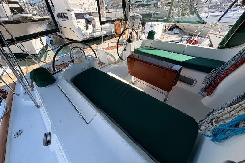 Slide: The Image of 2003 Beneteau Oceanis Clipper 473 cockpit with green cushions and steering wheel. - 28
