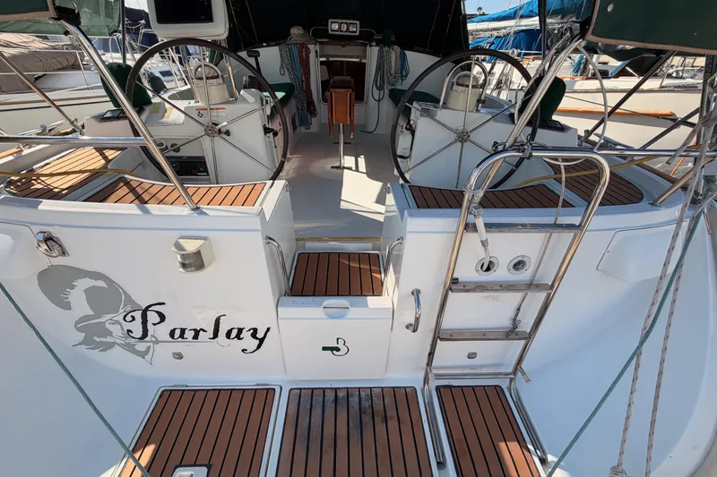 Slide: The Image of 2003 Beneteau Oceanis Clipper 473 sailboat cockpit with dual steering wheels and teak flooring. - 3