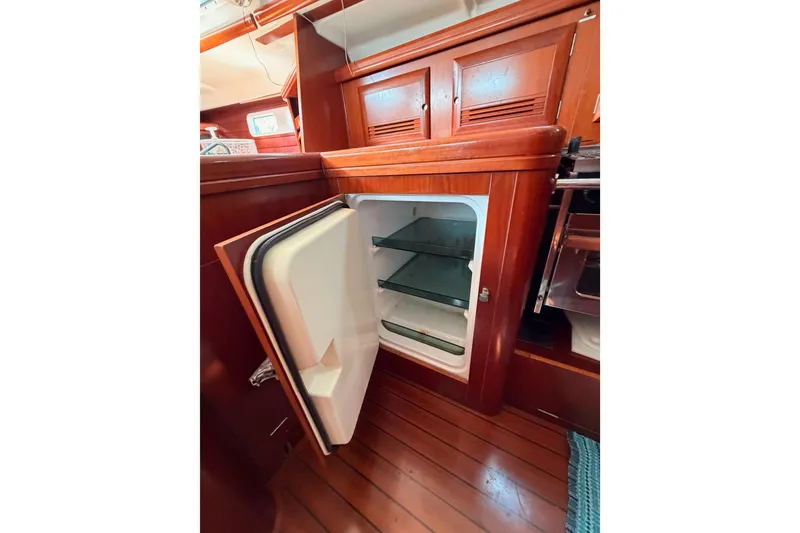Slide: The Image of Open refrigerator inside 2003 Beneteau Oceanis Clipper 473 yacht, showcasing wooden interior design. - 37