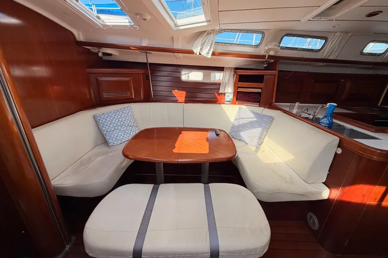 Slide: The Image of Interior of 2003 Beneteau Oceanis Clipper 473 yacht with cozy seating and wooden table. - 52
