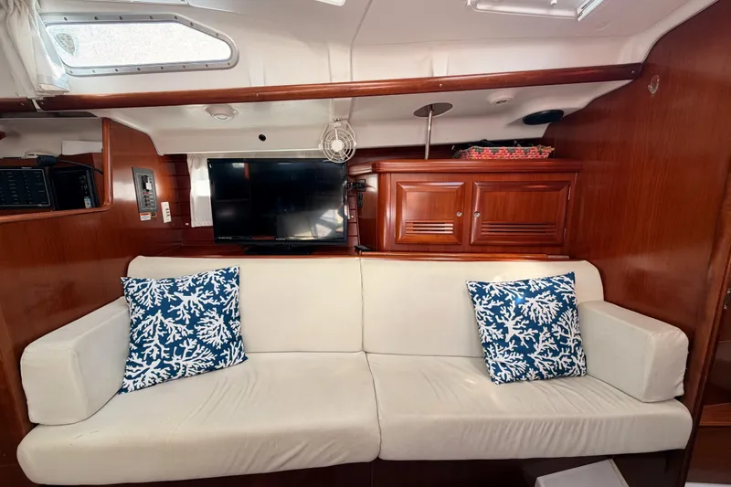 Slide: The Image of Interior of 2003 Beneteau Oceanis Clipper 473 with white sofa and blue coral pillows. - 53