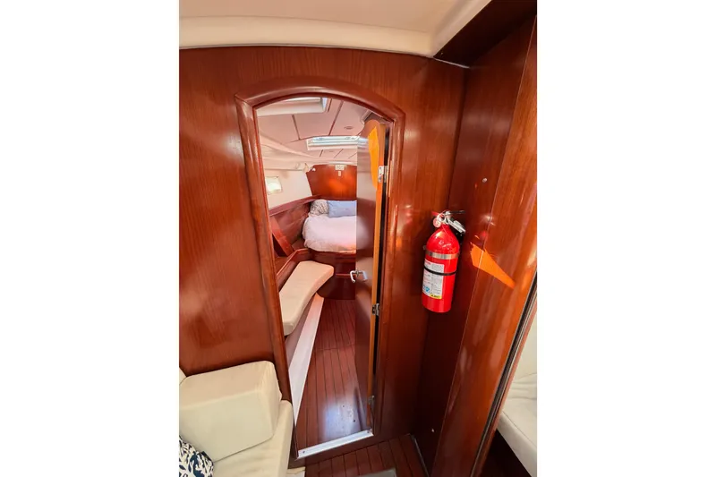 Slide: The Image of Interior of 2003 Beneteau Oceanis Clipper 473 yacht, featuring wood paneling and cozy cabin. - 54