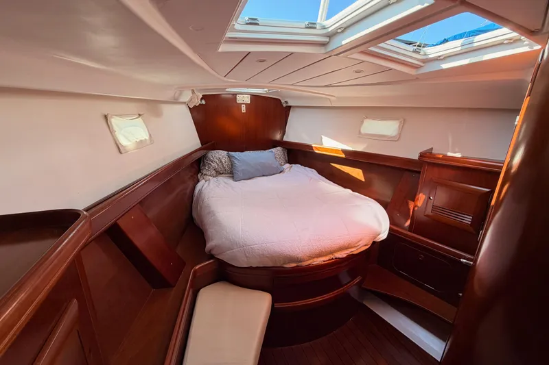 Slide: The Image of Luxurious cabin interior of 2003 Beneteau Oceanis Clipper 473 sailboat, featuring a cozy bed. - 56