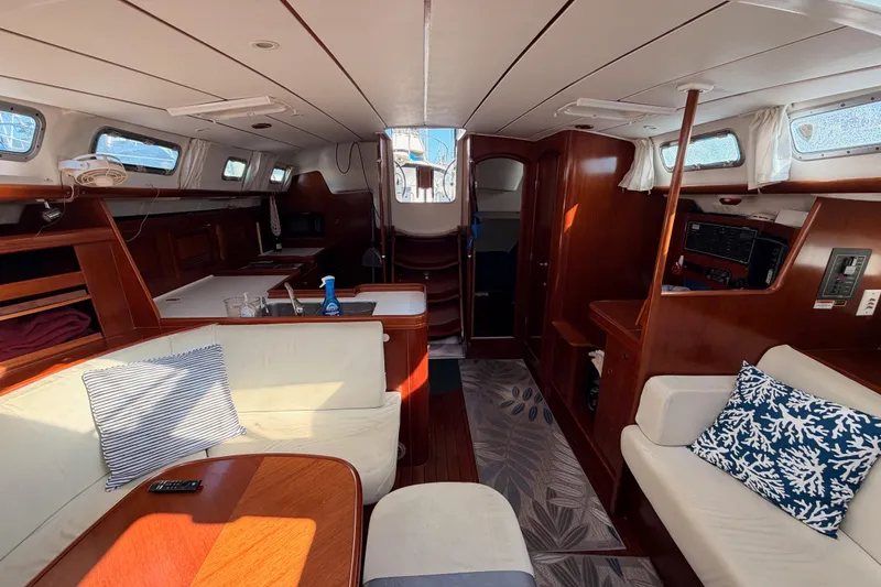 Slide: The Image of Interior of 2003 Beneteau Oceanis Clipper 473 yacht, featuring elegant wood finishes and cozy seating. - 64