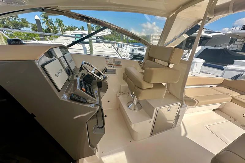 Slide: The Image of 2015 Pursuit SC 365i Sport Coupe helm with Garmin displays and beige seating. - 16