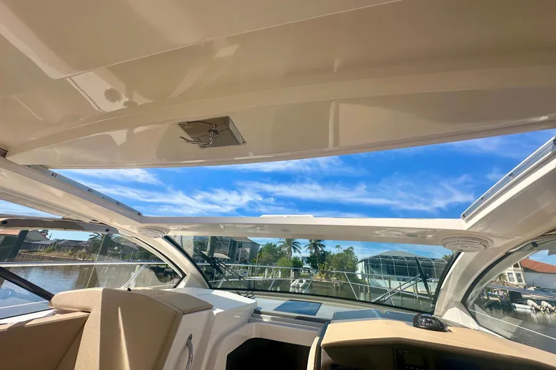 Slide: The Image of 2015 Pursuit SC 365i Sport Coupe interior with open sunroof, showcasing waterfront view. - 20