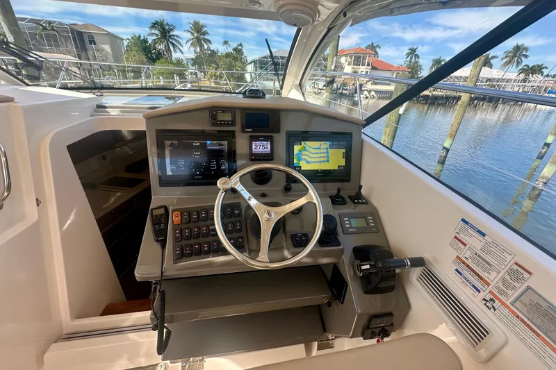 Slide: The Image of 2015 Pursuit SC 365i Sport Coupe helm with navigation screens and steering wheel. - 21
