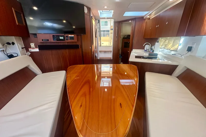 Slide: The Image of Luxurious interior of 2015 Pursuit SC 365i Sport Coupe with polished wood table and seating. - 26