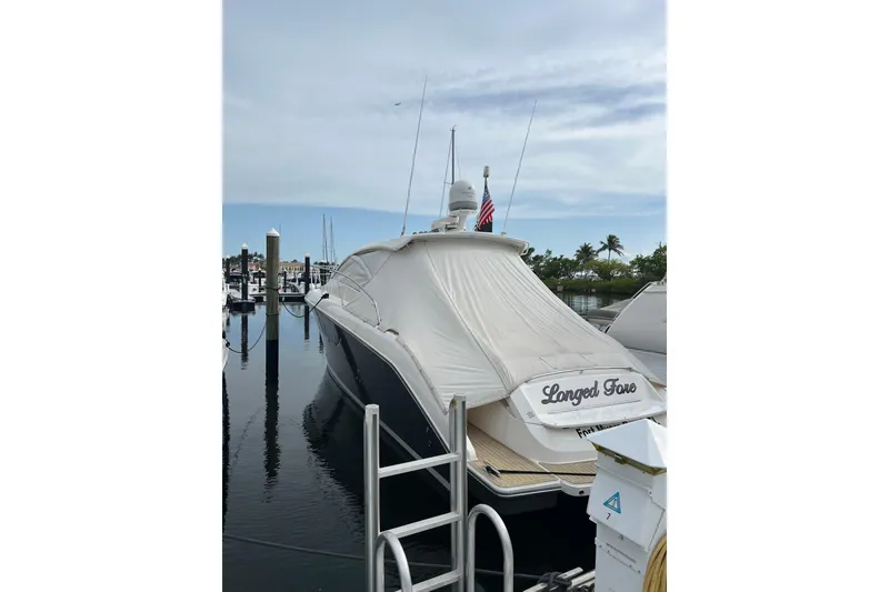Slide: The Image of 2015 Pursuit SC 365i Sport Coupe docked with cover, marina background. - 33