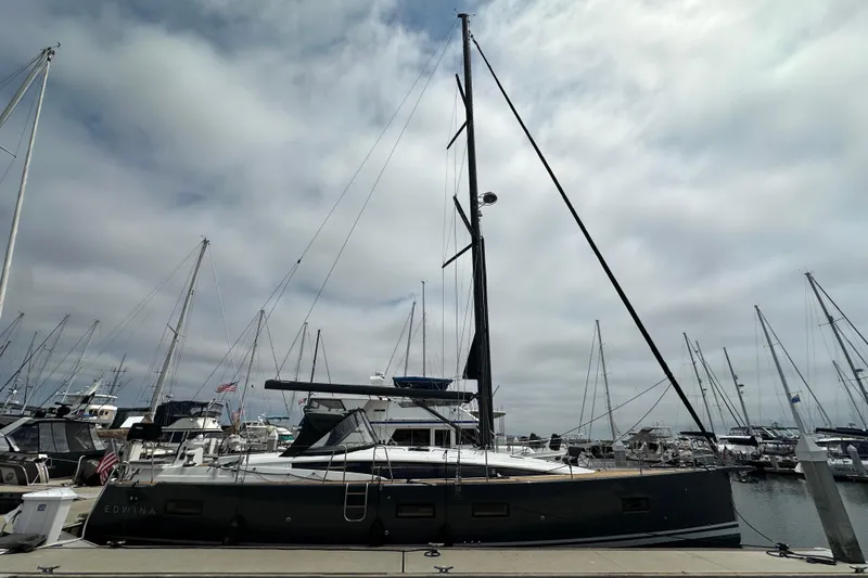Slide: The Image of 2018 Jeanneau 54 sailboat docked at marina under cloudy sky. - 11