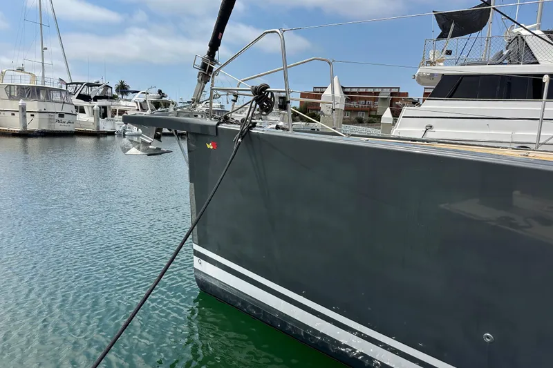 Slide: The Image of 2018 Jeanneau 54 yacht docked in marina, featuring sleek gray hull and anchor. - 12