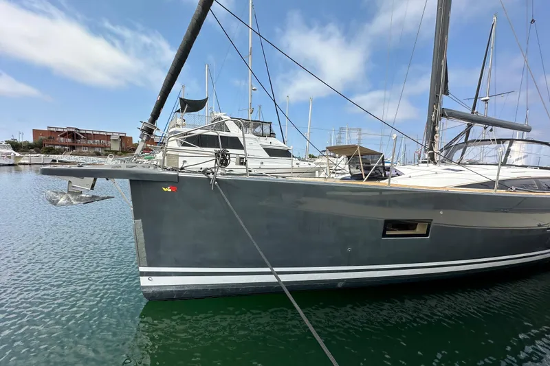 Slide: The Image of 2018 Jeanneau 54 yacht docked in marina, sleek design, clear sky background. - 13