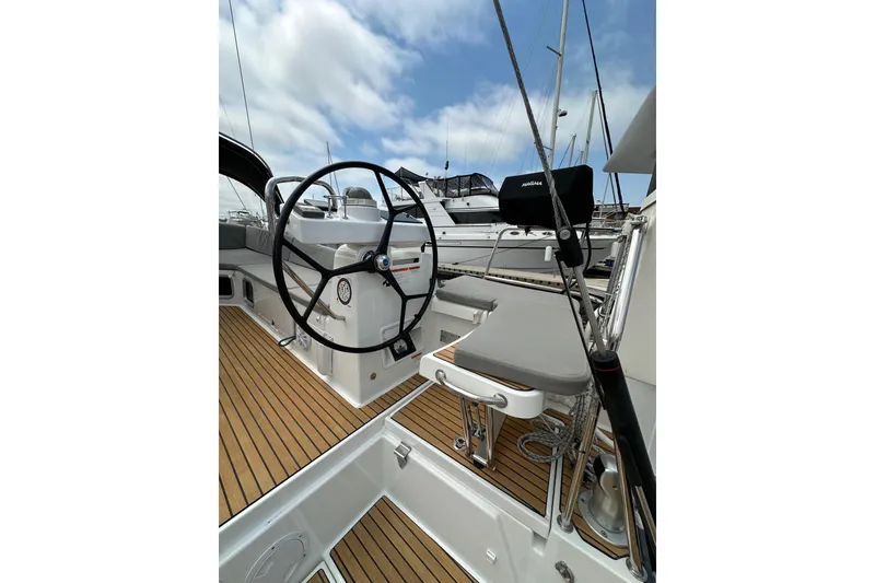 Slide: The Image of Steering wheel of 2018 Jeanneau 54 yacht with teak deck, docked at marina. - 25