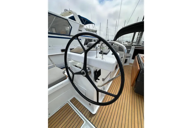 Slide: The Image of Steering wheel of a 2018 Jeanneau 54 yacht, featuring teak decking and modern design. - 26