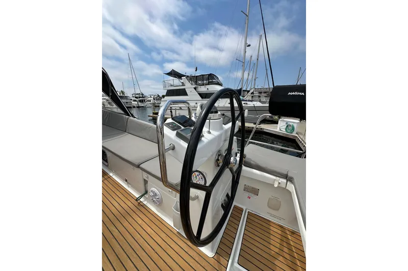 Slide: The Image of 2018 Jeanneau 54 yacht helm with sleek design and marina view. - 32