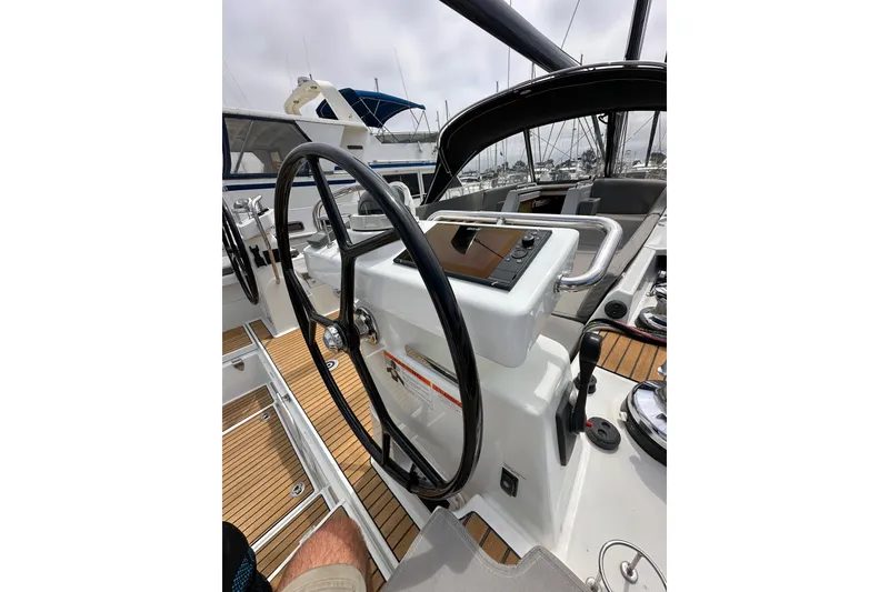 Slide: The Image of Steering wheel and controls of a 2018 Jeanneau 54 yacht, featuring sleek design and wood accents. - 34