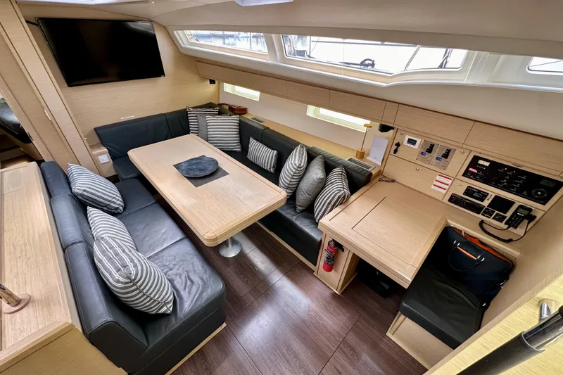 Slide: The Image of 2018 Jeanneau 54 yacht interior with navigation station, control panels, and seating area. - 65
