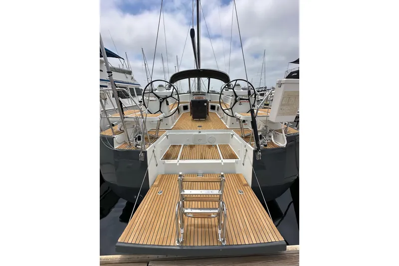 Slide: The Image of 2018 Jeanneau 54 yacht with dual steering wheels and teak deck in a marina. - 7