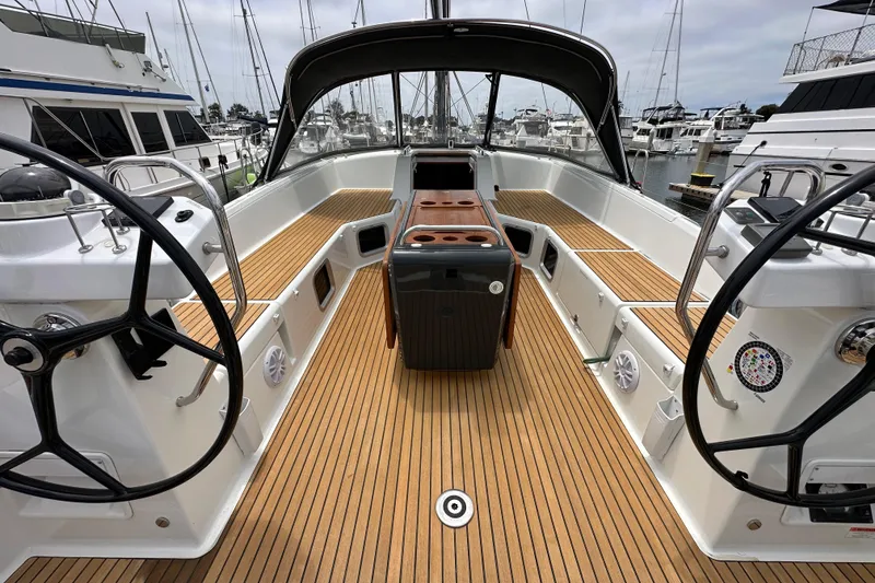 Slide: The Image of 2018 Jeanneau 54 yacht cockpit with dual steering wheels and teak flooring at marina. - 8