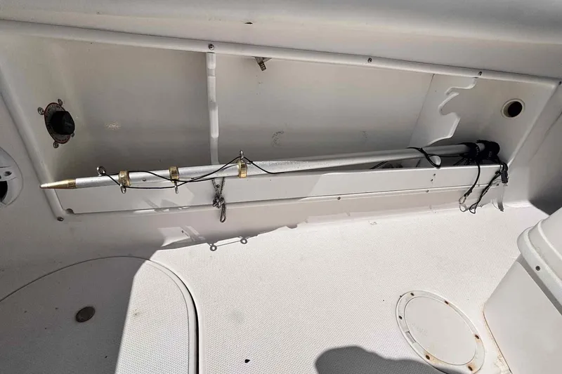 Slide: The Image of 1997 Wellcraft 302 Scarab boat docked, featuring a maroon canopy and spacious seating. - 10