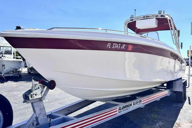 Slide: The Image of 1997 Wellcraft 302 Scarab boat on trailer, white and maroon, sunny day. - 27